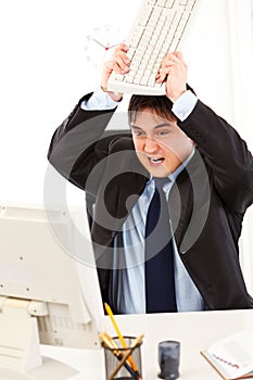 Businessman destroying computer using keyboard