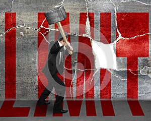 Businessman destructing the wall with a large hammer