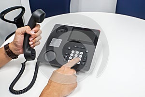 Businessman dial on IP phone calling out to customers