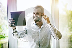 Businessman with digital tablet and earphones