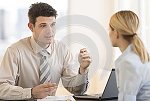 Businessman Discussing With Colleague In Meeting At Office