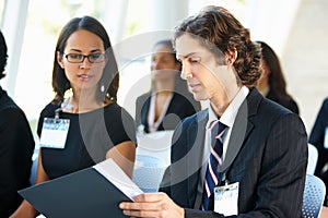 Businessman Discussing Conference Document With Colleague