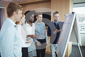 Businessman discussing over whiteboard with team