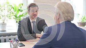 Businessman Discussing Work with Senior Old Businessman in Office