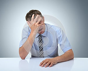 Businessman do a facepalm on white table