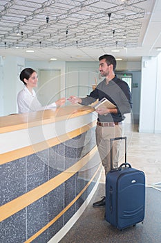 Businessman does checking and pays receptionist by credit card pay