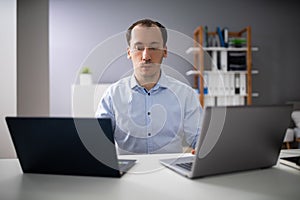 Businessman Doing Multitasking Work In Office