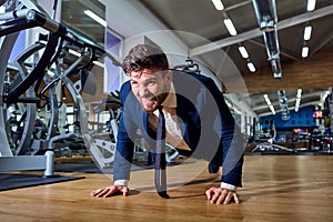 Businessman doing push-ups in the gym.