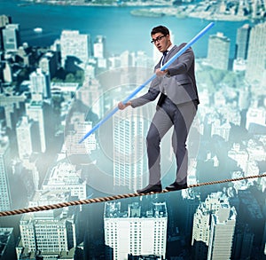 Businessman doing tightrope walking in risk concept