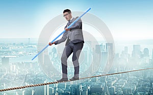 The businessman doing tightrope walking in risk concept