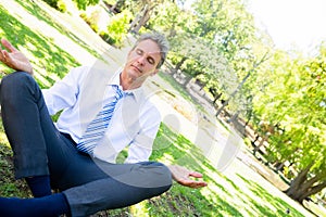 Businessman doing yoga in park