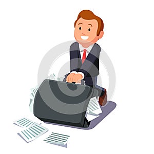 Businessman dragging huge briefcase full of papers