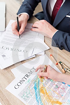 Businessman drawing on business papers with son