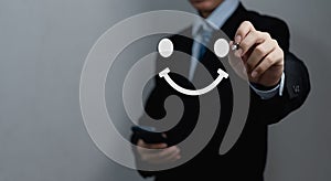 Businessman drawing a happy face smile face. Customer service experience, satisfaction survey, feedback and review concepts