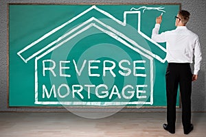 Businessman Drawing House With Reverse Mortgage Text