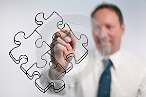 Businessman Drawing Puzzle Pieces