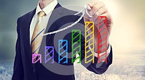 Businessman drawing a rising arrow over a bar graph