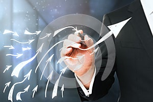 Businessman drawing rising arrows