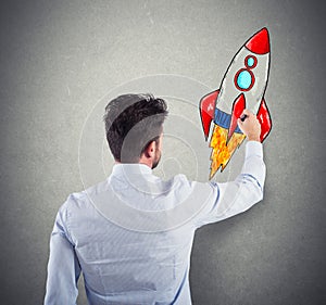 Businessman drawing a rocket. Concept of business improvement and enterprise startup