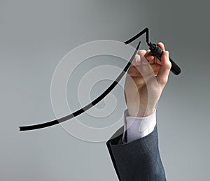Businessman drawing a uptrend chart photo