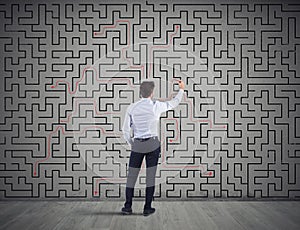 Businessman draws the solution of a labyrinth. Concept of problem solving