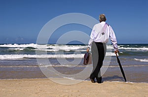 Businessman dreaming of retirement freedom on a tropical beach, copy space