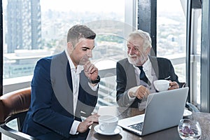 businessman drinking coffee and talk business deal at skyscraper office lounge with cityscape business zone background