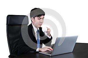 Businessman drinking coffee / tea and using computer