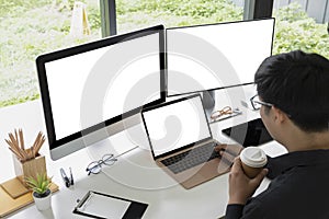 Businessman drinking coffee and working with multiple modern devices.