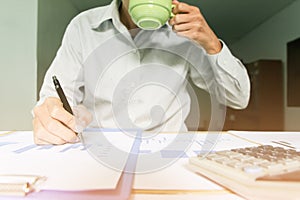 businessman drinking coffee and working point to discuss the graph up and down of economy