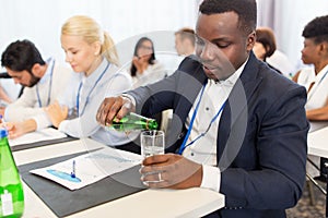 Businessman drinking water at business conference