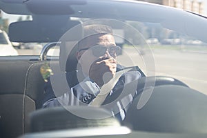 A businessman driving a car covers his mouth with his hand, an emotion of surprise or shock. Accident on the road