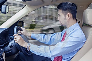 Businessman driving a car on the road