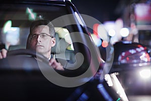 Businessman driving at night in the city