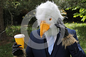 Businessman with an eagle face making a phone call