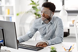 Businessman with earphones and computer at office