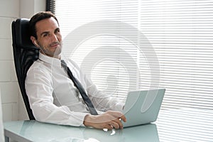 Businessman with earphones and laptop computer