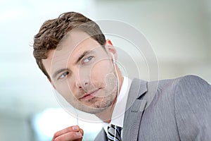 Businessman with earphones talking on phone