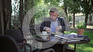 Businessman eating lunch. Outdoor. Steadycam shot.