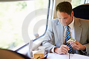 Businessman Eating Sandwich On Train Journey