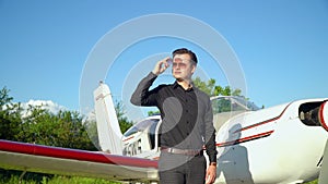 Businessman in elegant suit near the his small airplane before the flight