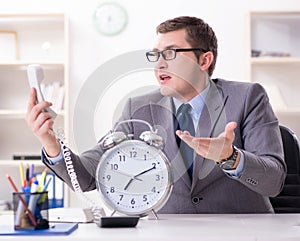 Businessman employee in urgency and deadline concept with alarm