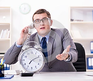 Businessman employee in urgency and deadline concept with alarm