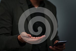 businessman with empty hand and open palm offering something while using smartphone