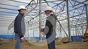 Businessman, engineer, architect, contractor, customer, manager, builder in hard hats having agreement handshake on