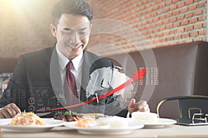 Businessman holding fork and knife eating steak, business and food/restaurant concept