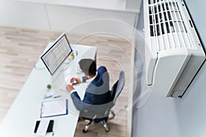 Businessman Enjoying The Cooling Of Air Conditioner photo