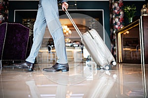 Businessman entering hotel with luggage. photo