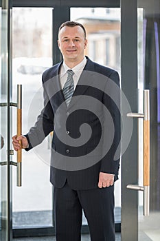 A businessman enters the glass door photo