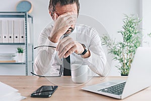 Businessman and entrepreneur realizing the big mistake he made, hand covering face in disbelief